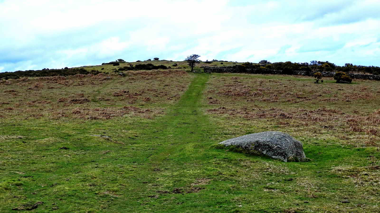 Beside the path to Cripdown Tor there is a large earthbound stone